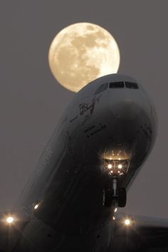 an airplane with the moon in the background