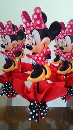 there are many minnie mouses on display in the vase with ribbons and bows around them