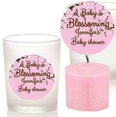 two candles with labels on them sitting next to each other in front of a white background