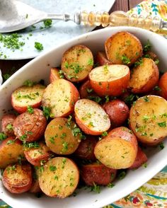 a white bowl filled with potatoes on top of a table