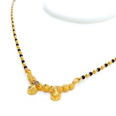 This exquisite Thali Mangal Sutra, crafted in 22k yellow gold, weighs 9.2 grams and features a classic design adorned with traditional black beads. With a necklace length of 16" and a subtle 0.25" drop, it embodies grace and simplicity. Secured with a hook lock, this piece is a timeless representation of cultural heritage, perfect for daily wear or special occasions, adding a touch of elegance and meaning to any ensemble. PRODUCT DETAILS Gold Purity(karat): 22k Item Weight(grams): 9.2 Item Finish: Yellow Gold Stone: Black Bead Necklace Length: 16" Drop Length: 0.25" Lock Style: Hook Lock Yellow Gold Necklace With Latkans For Puja, Traditional Yellow Gold Dual-tone Necklaces, Black Round Beads Necklaces For Puja, Black Round Beaded Necklaces For Puja, Gold Necklace With Black Beads For Puja, Black Round Beads Necklace For Diwali, Gold Jewelry With Black Beads For Puja, Black Temple Jewelry Necklaces For Puja, Black Temple Jewelry Necklace For Puja