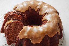 a chocolate bundt cake with icing on a glass plate