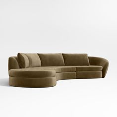 a large sectional sofa with an ottoman on the bottom and side, sitting in front of a white wall