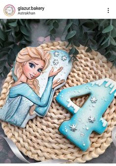 there is a decorated cookie with the letter e and a frozen princess figure on it