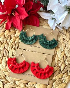 two pairs of red and green tasseled earrings on top of a woven basket