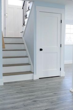 an empty room with stairs and white doors