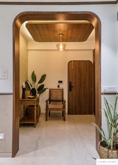 an entry way with a chair and potted plant in the center, next to a wooden door