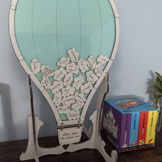 a wooden table topped with a blue and white hot air balloon filled with lots of flowers