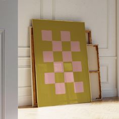 a yellow and pink painting sitting on top of a hard wood floor next to a white door