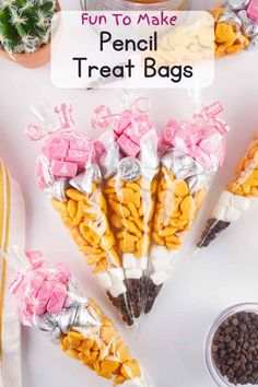 some candy sticks are wrapped in plastic and sitting on a table next to cacti