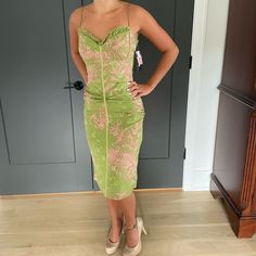 a woman standing in front of a door wearing a green dress