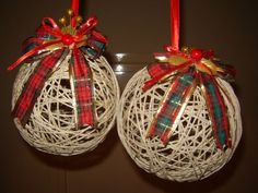 two christmas ornaments hanging from strings with bows