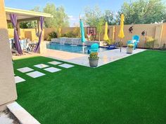 a backyard with artificial grass and lawn furniture