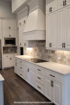 a kitchen with white cabinets and marble counter tops in the middle of it is shown