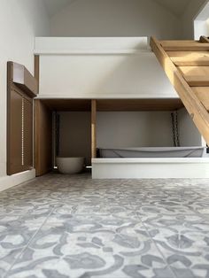 an open loft space with stairs leading up to the bed area and bathroom in the background