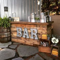 a wooden sign that says bar on it next to some potted plants and other items