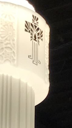 a close up of a white light fixture with an ornate design on the top and bottom