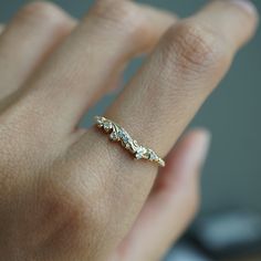 a woman's hand with a gold ring on it and three diamonds in the middle