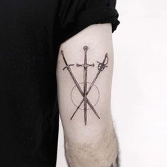 a man's arm with two crossed swords on it