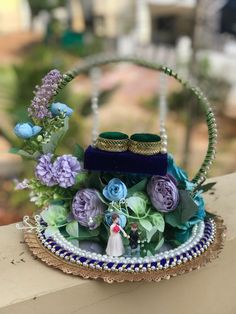 a small purse with flowers and pearls on the handle is sitting on a table outside