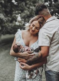 a man and woman holding a baby in their arms