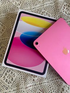 two apple ipads sitting next to each other on a lace tablecloth covered surface