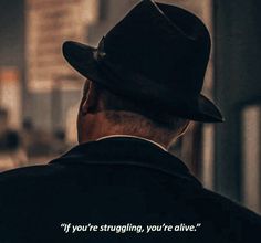 an older man wearing a fedora looking at the street with a quote on it that says, if you're struggling, you're alive alive