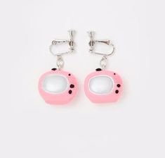 pair of pink earrings with white and black dots on the front, hanging from silver hooks