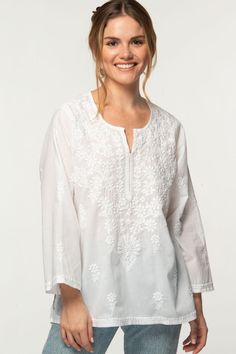 "Our Tara Tunic is hand embroidered by women artisans in Northern India in the shadow-work style known as \"Chikankari\". Chikankari is a delicate and artfully done hand embroidery technique that women in this region have been doing for generations.  Available in two sizes, S/M and L/XL, this beautiful 100% cotton tunic is designed for a comfortable and elegant fit." Luxury Chikankari Embroidered Tops For Party, Luxury Bollywood Tops With Chikankari Embroidery, Cotton Embroidered Fabric With Woven Motifs, Bohemian Chikankari Embroidered Tunic Top, White Folk Blouse With Resham Embroidery, Traditional White Top With Intricate Embroidery, Festive Traditional Tops With Tonal Embroidery, Transitional Tops With Resham Embroidery, Multicolor Embroidered Folk Fabric