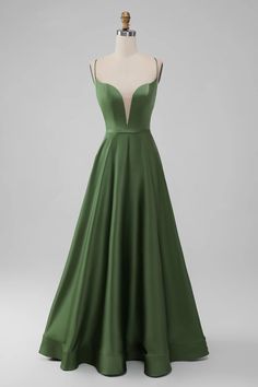 a green evening gown on a mannequin headdress in front of a gray background