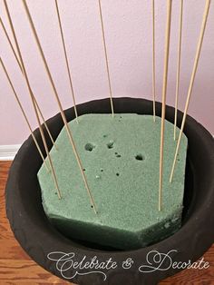 a green cake with sticks sticking out of it