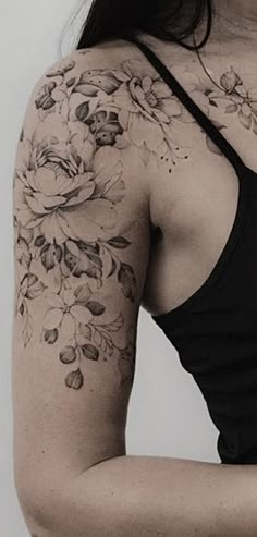 a woman with a flower tattoo on her arm and shoulder is holding a cell phone