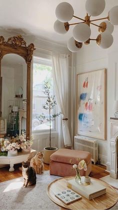 a living room filled with furniture and a cat sitting on top of a coffee table