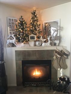 a fireplace decorated with christmas trees and stockings