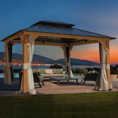 a gazebo sitting on top of a wooden deck next to a lake at night