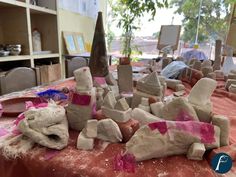 clay sculptures are sitting on a table in the middle of a room