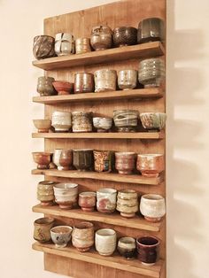 a wooden shelf filled with lots of bowls