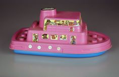 a pink toy boat sitting on top of a table