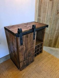 a wooden crate sitting on top of a hard wood floor next to a white wall