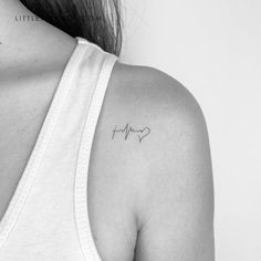 the back of a woman's shoulder with a small heartbeat tattoo on her left arm