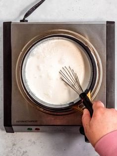 a person whisk milk in a blender