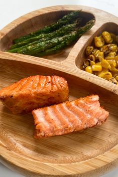 salmon, corn and asparagus on a wooden plate