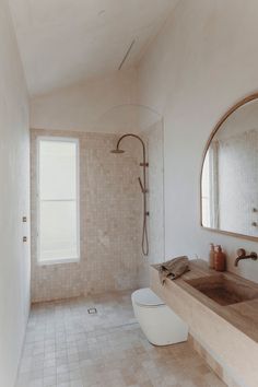 a bathroom with a toilet, sink and shower head in it's center wall