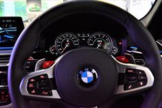 the steering wheel and dashboard of a bmw car