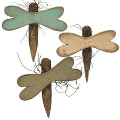 three wooden dragonflys are hanging on the wall