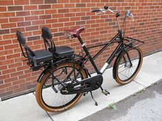 a bicycle parked next to a brick wall