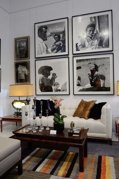 a living room filled with furniture and pictures hanging on the wall above it's coffee table