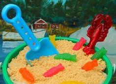 a green bucket filled with sand and plastic toys