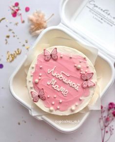 a pink birthday cake with butterflies on it