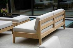 two wooden benches sitting next to each other on top of a cement floor near a glass wall